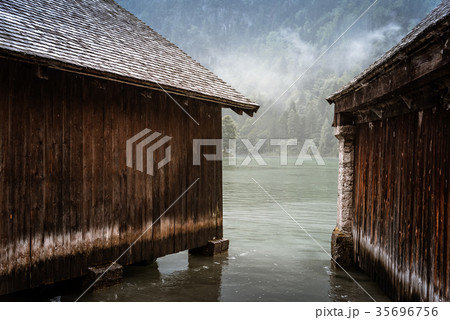 Wooden cottages in Konigssee lake a misty summer 35696756