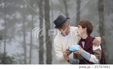 Happy senior man surprises wife with present  35707681