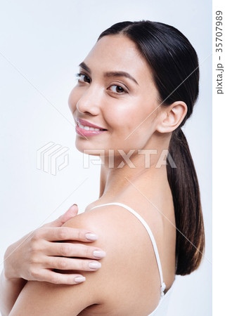 Cheerful dark-haired woman posing with hand on 35707989