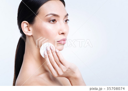 Gorgeous woman removing foundation from her face 35708074