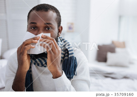 Calm ill man using soft handkerchief at home 35709160