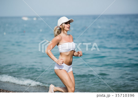 Beautiful young blonde woman in white sportswear Beautiful young blonde woman in white sportswear 35710396