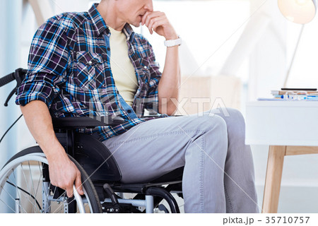 Serious disabled male person sitting on his 35710757
