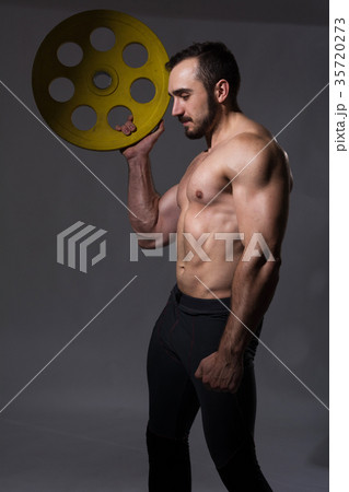 Muscular bodybuilder guy doing exercises with dumbbell Muscular bodybuilder guy doing exercises with dumbbell 35720273
