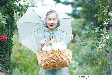 庭で日傘をさすシニア女性 庭で日傘をさすシニア女性 35722203
