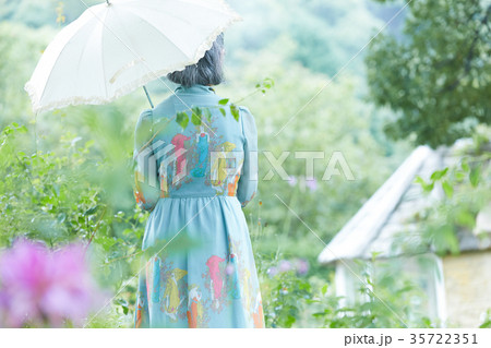 庭で日傘をさすシニア女性 庭で日傘をさすシニア女性 35722351