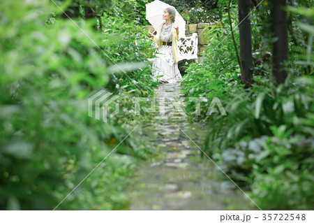 庭で日傘をさすシニア女性 庭で日傘をさすシニア女性 35722548