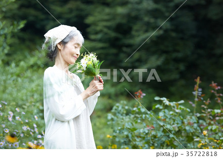 花の香りを嗅ぐシニア女性の写真素材
