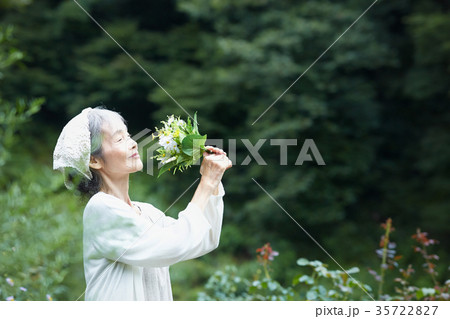 花の香りを嗅ぐシニア女性 花の香りを嗅ぐシニア女性 35722827