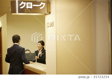 クロークに荷物を預ける男性 35723254
