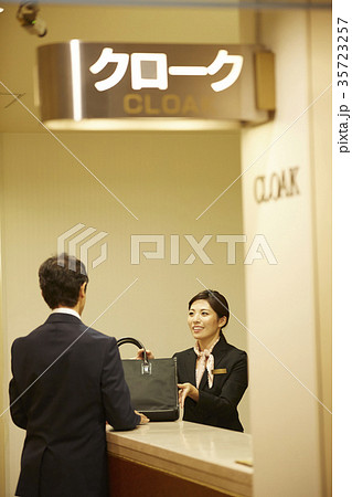 クロークに荷物を預ける男性 35723257