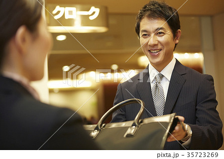 クロークに荷物を預ける男性 35723269