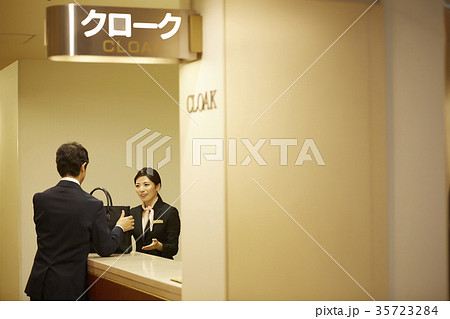 クロークに荷物を預ける男性 35723284