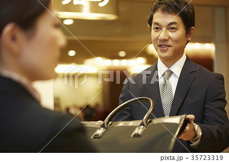 クロークに荷物を預ける男性 35723319