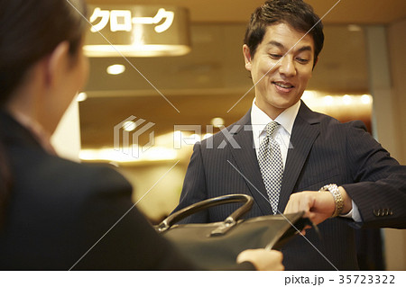 クロークに荷物を預ける男性 35723322