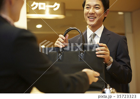 クロークに荷物を預ける男性 35723323