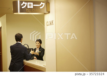 クロークに荷物を預ける男性 35723324