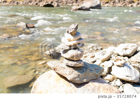 Balanced stone pyramid blue water Mountain River. Balanced stone pyramid blue water Mountain River. 35728074