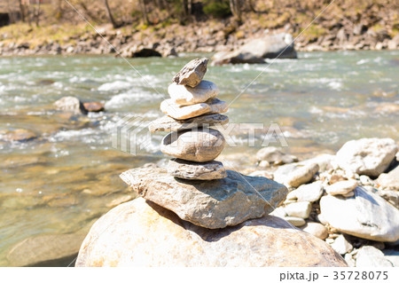 Balanced stone pyramid blue water Mountain River. Balanced stone pyramid blue water Mountain River. 35728075