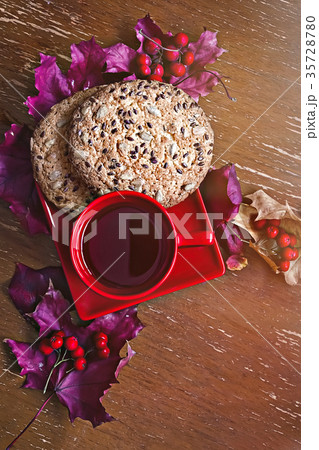 Red Cup with cookies, autumn leaves and berries Red Cup with cookies, autumn leaves and berries 35728780