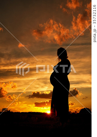 Silhouette of a pregnant woman at sunset Silhouette of a pregnant woman at sunset 35732116