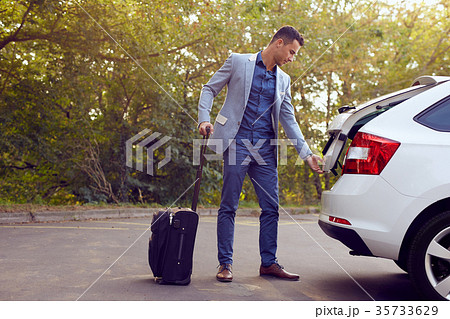 Business man opens car trunk Business man opens car trunk 35733629
