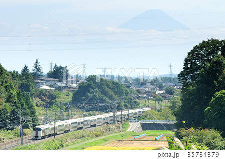 富士山をバックに黄金色に輝く田園を走る中央線ホリデー快速ビューやまなし 35734379