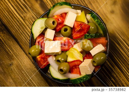 Greek salad in glass bowl on wooden table 35738982