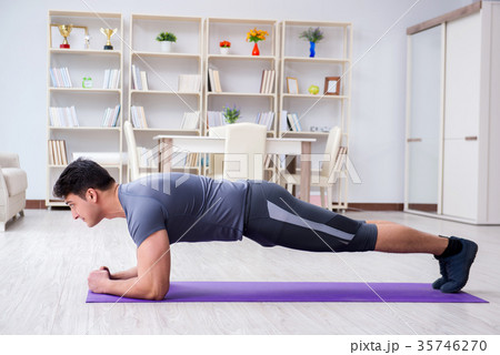 Young man exercising at home in sports and healthy 35746270