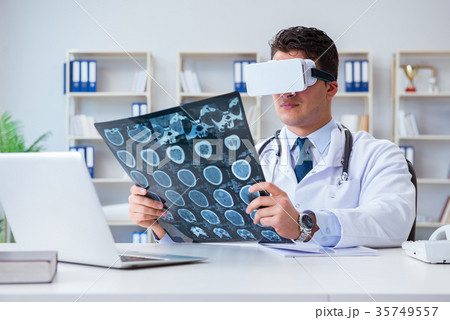 Young doctor looking at MRI scan through VR 35749557