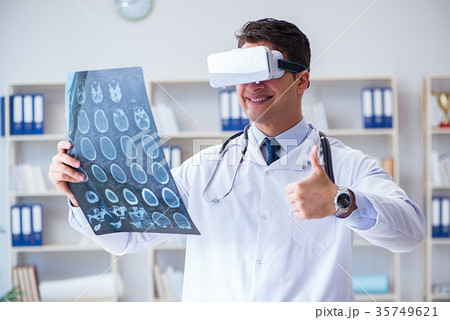 Young doctor looking at MRI scan through VR Young doctor looking at MRI scan through VR 35749621