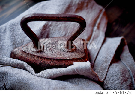 Old heavy cast-iron iron on a piece of burlap 35761376
