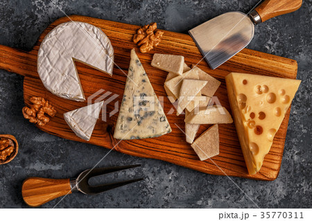 Assorted cheeses on wooden board. Assorted cheeses on wooden board. 35770311