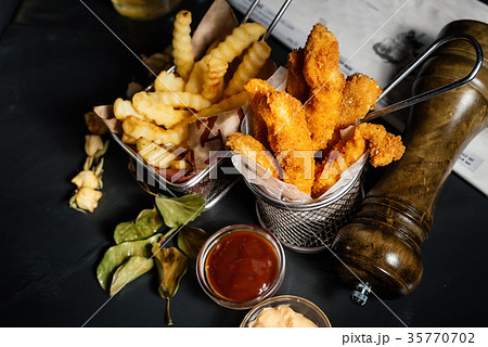 Fried chicken tenders with fries served at pub 35770702