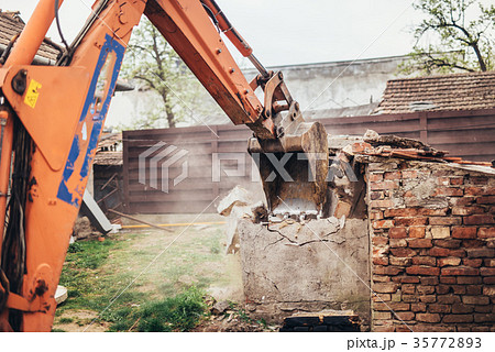 industrial bulldozer crushing an old building industrial bulldozer crushing an old building 35772893