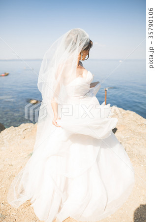 Lovely bride in white wedding dress posing near Lovely bride in white wedding dress posing near 35790106