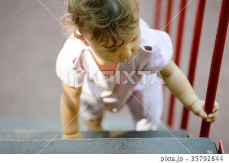 The one-year child climbs up the stairs The one-year child climbs up the stairs 35792844