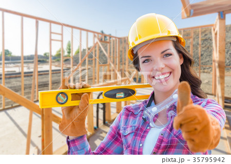 Female Construction Worker with Thumbs Up Holding Level Wearing 35795942