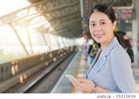 girl holding a mobile phone standing on platform girl holding a mobile phone standing on platform 35815639