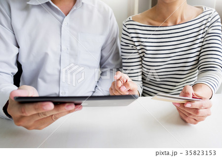 Happy young couple doing  shopping online at home with tablet. 35823153
