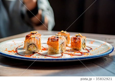 Food photographer takes picure of sushi rolls 35832921