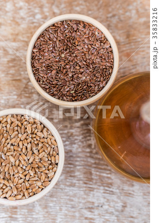 Wooden bowls with flax and wheat grain and oil Wooden bowls with flax and wheat grain and oil 35833216