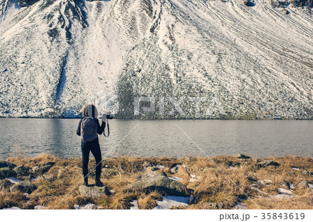 A woman photographer with camera on lake in Swis 35843619