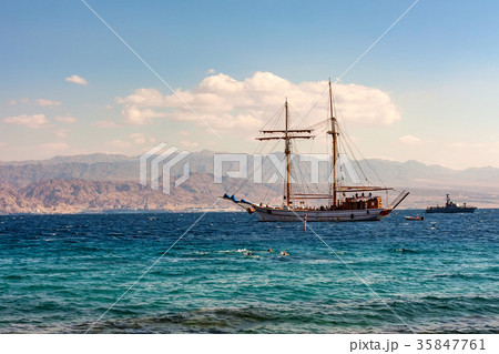 Sailing boat in sea with mountains in background Sailing boat in sea with mountains in background 35847761