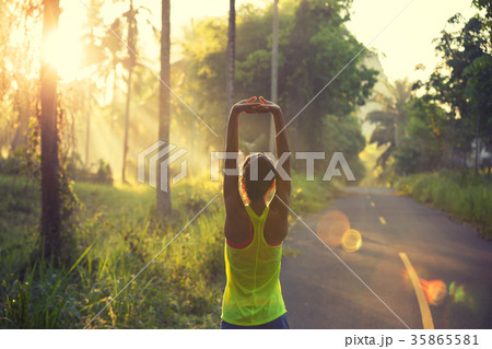 woman runner warming up on sunrise forest trail woman runner warming up on sunrise forest trail 35865581