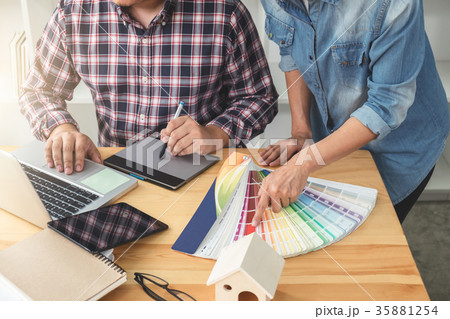 Young colleagues designers working together on a creative projec Young colleagues designers working together on a creative projec 35881254