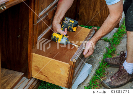 workman fixing cabinet with screwdriver kitchen 35885771
