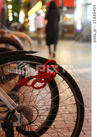 夜の繁華街、歩道に並ぶ自転車の駐輪所と街並み、歩く人 夜の繁華街、歩道に並ぶ自転車の駐輪所と街並み、歩く人 35888404