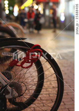 夜の繁華街、歩道に並ぶ自転車の駐輪所と街並み、歩く人 夜の繁華街、歩道に並ぶ自転車の駐輪所と街並み、歩く人 35888406