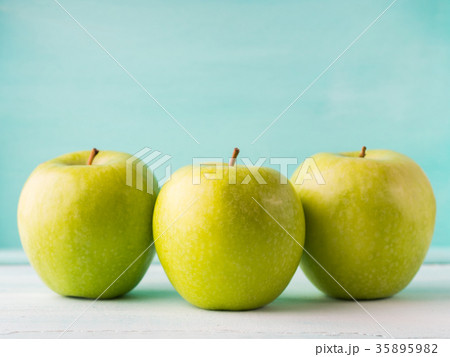 Three Green apples on turquoise background Three Green apples on turquoise background 35895982